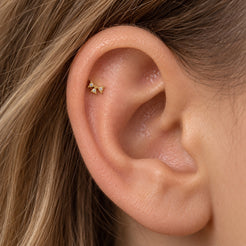 Fiocco solid 18K gold bow piercing worn on ear